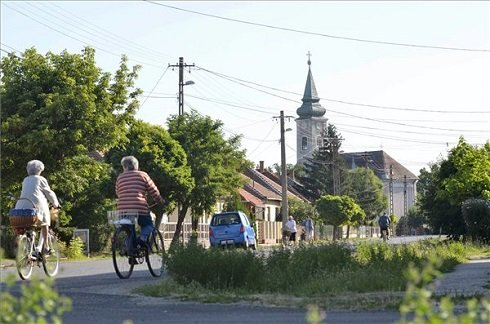 Kerékpárosok a Jász-Nagykun-Szolnok megyei Besenyszögön 2013. július 12-én. Besenyszög azon tizennyolc település egyike, amelynek városi címet adományozott a köztársasági elnök 2013. július 15-ei hatállyal. MTI Fotó: Mészáros János