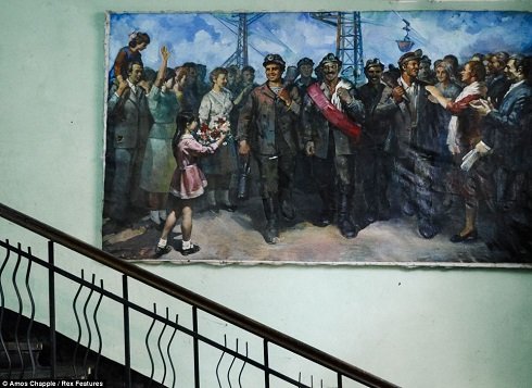 Még ma is a kommunista időket idézi az állomás épületének falán a festmény.